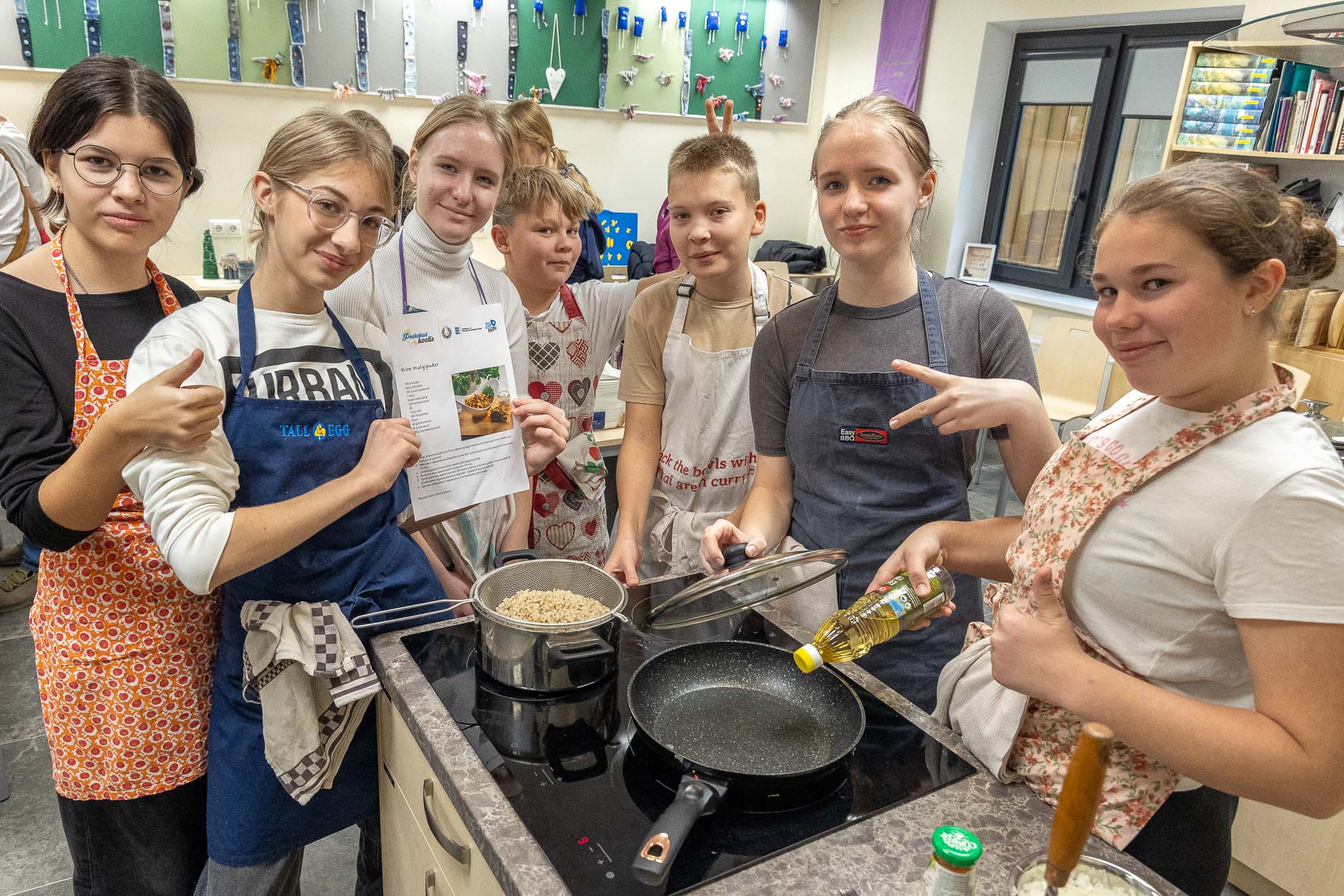Vasakult: Puiga põhikooli 7. klassi õpilased Eva Lote Davõdov, Emma Casey Kibena, Annabel Märdimäe, Sten Martin Sammelsoo, Georg Kõlli, Annete Märdimäe, Marta Salumets neljapäeva hommikul kooli õppeköögis peakokaga koos toitu valmistamas. FOTOD: Aigar Nagel